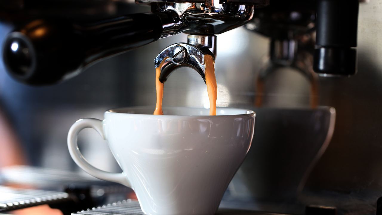 Expresso s'écoulant de la machine dans une tasse blanche